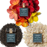 Flatlay of The Jet Set's perfume bottles on piles of their associated ingredients